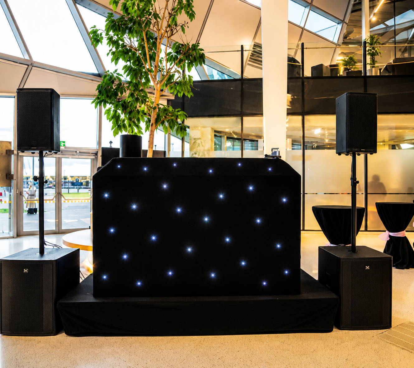 LED DJ booth setup with stage lighting and speakers for a corporate after-party event